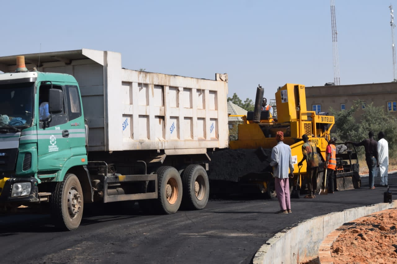 Tipper truck and paver on site